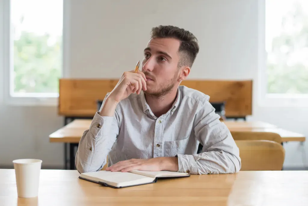 pensive-male-student-sitting-desk-classroom.jpg